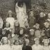 portrait en demi hauteur et en buste d'un groupe de d'écolières dans une cour devant la statue d'un ange