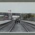 "A g. et à d. deux filles d'Eugène Lemaire. La gare de Jumet Hamendes, 1910" portrait en pied d'un groupe de 3 fillettes et 1 garçon entre les rails du chemin de fer en gare de Jumet-Hamendes à vocation de gare à marchandises