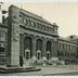 "4. Charleroi - L'Université du Travail Paul Pastur" vue en biais sur la façade et le portail d'entrée du bâtiment Zenobe Gramme construit en 1907 par Albert et Alexis Dumont et sur la statue et le monument à Paul Pastur