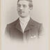 portrait en buste d'un jeune homme en studio portant une fine moustache